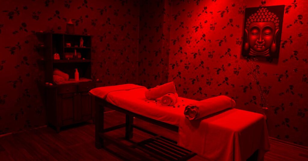 Serene massage room with red light therapy and infrared therapy lamp featuring a Buddha portrait, ideal for relaxation and self-care.