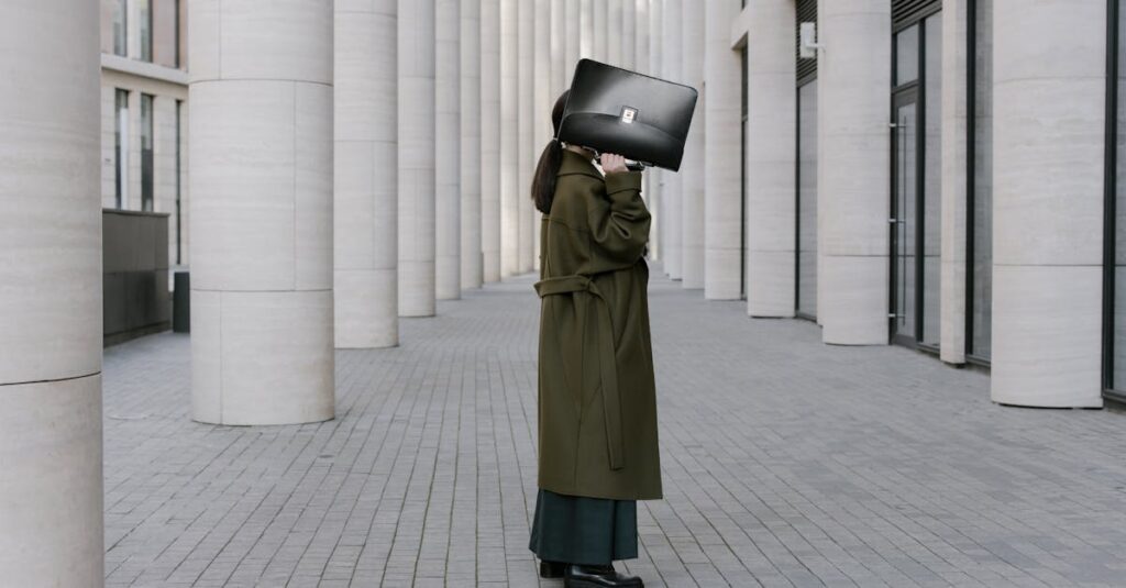 A stylish woman in an urban setting using a briefcase as a cover, exuding confidence.